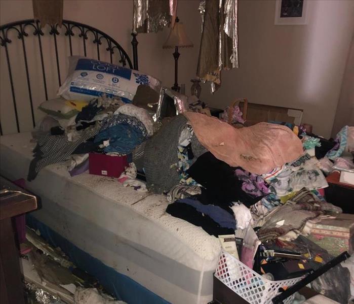 A photo showing damage content and furniture in a bedroom.