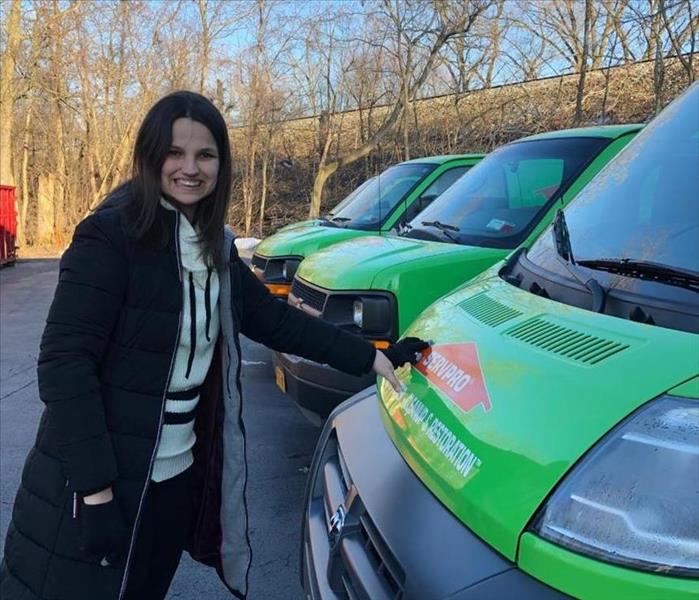 A photo of the owners daughter who has autism and is standing next to a SERVPRO van